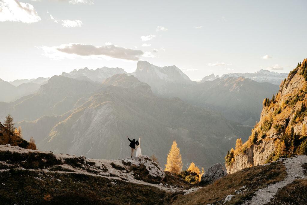 Couple embraces on scenic mountain trail.