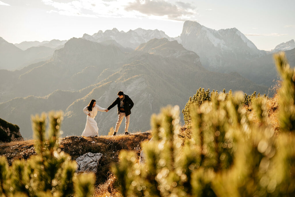 Couple holding hands on mountain landscape.
