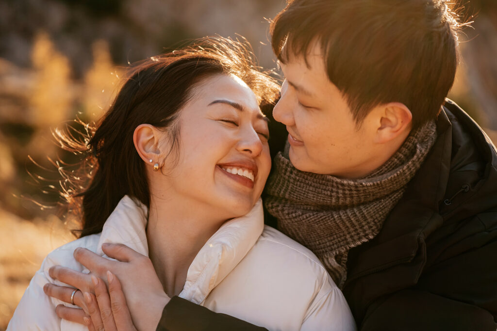 Couple embracing and smiling outdoors.