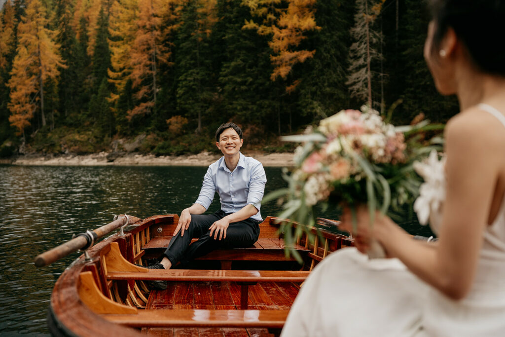 Couple in boat, autumn forest background.