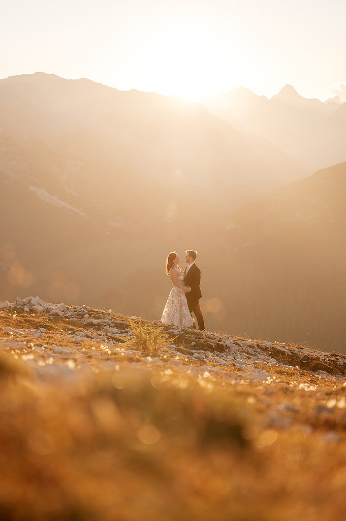 Couple embracing on mountain at sunset