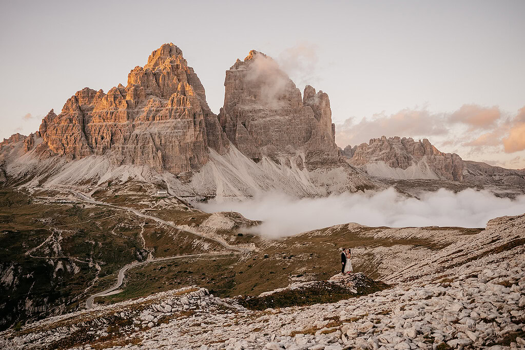 Couple embracing with scenic mountains in the background.