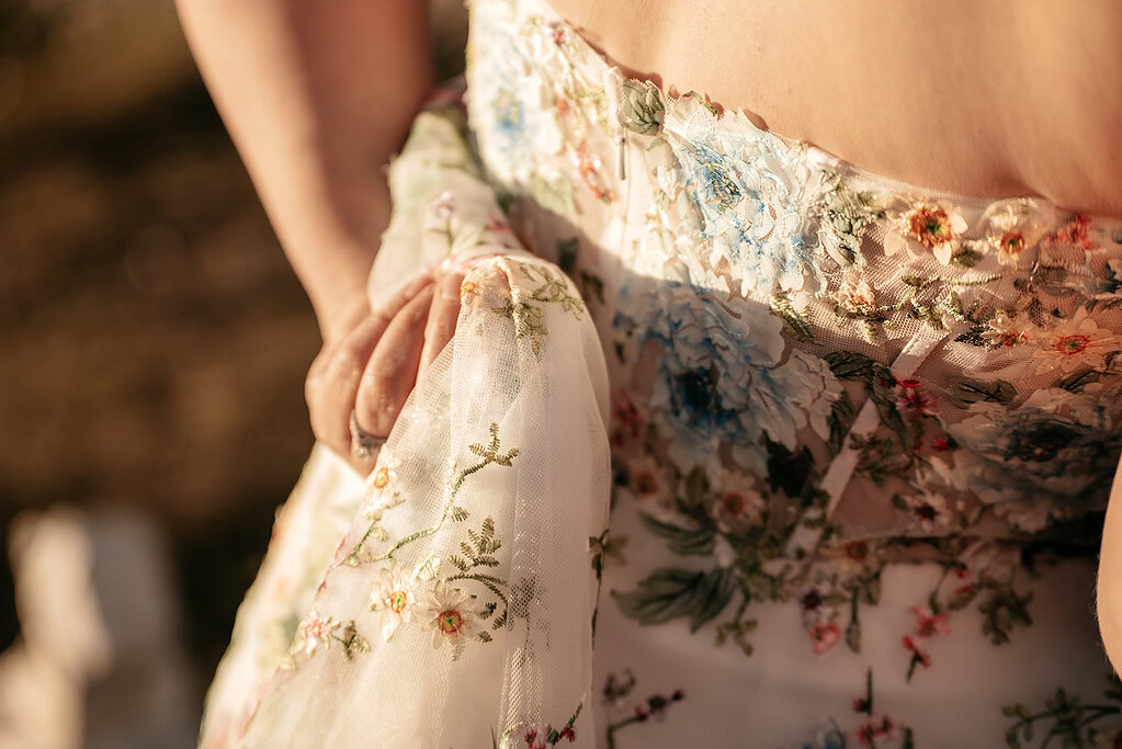 Close-up of floral embroidered dress in sunlight.