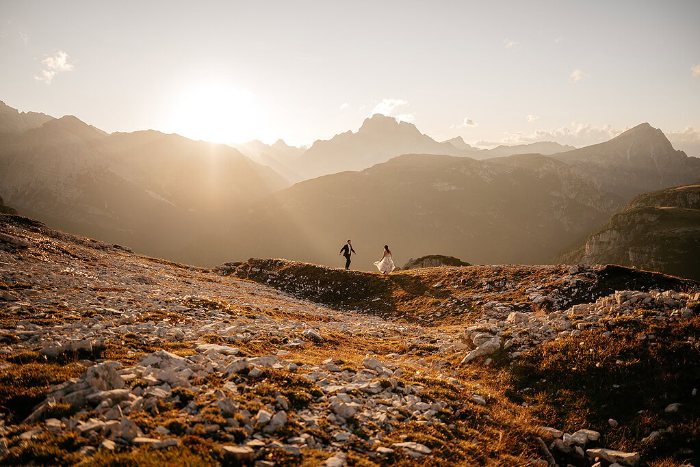 Couple running in mountainous sunset landscape