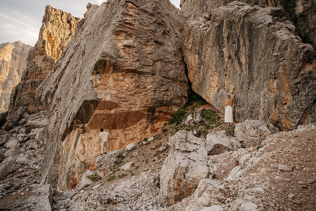 Two people exploring rocky mountain landscape.
