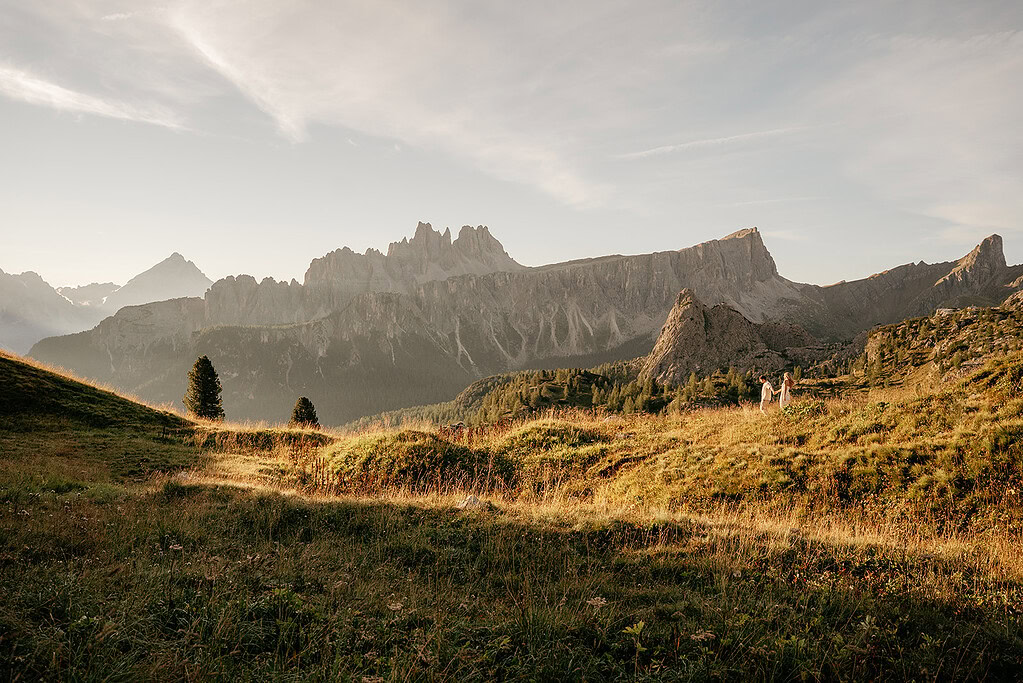 Mountain landscape with grassy hills and distant peaks.