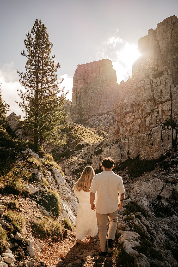 Couple hiking scenic mountain trail at sunrise.