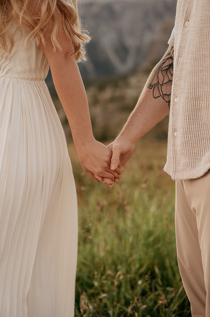 Couple holding hands in a field