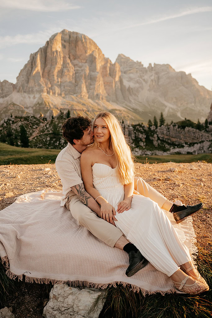 Couple sitting on blanket in scenic mountains
