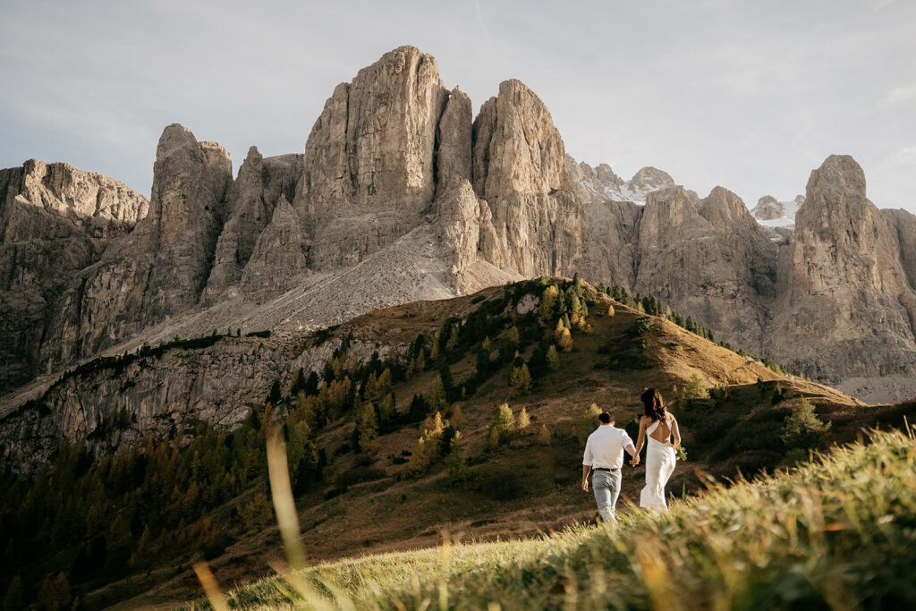 Couple walking towards majestic mountain scenery.