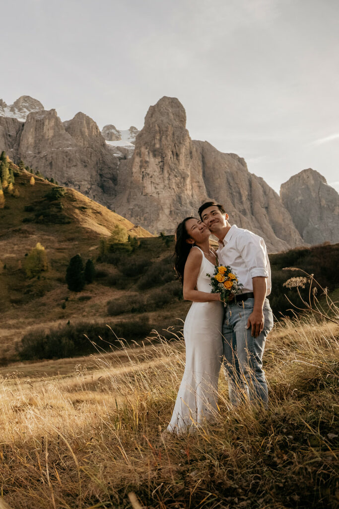 Couple embracing in mountain landscape at sunset.