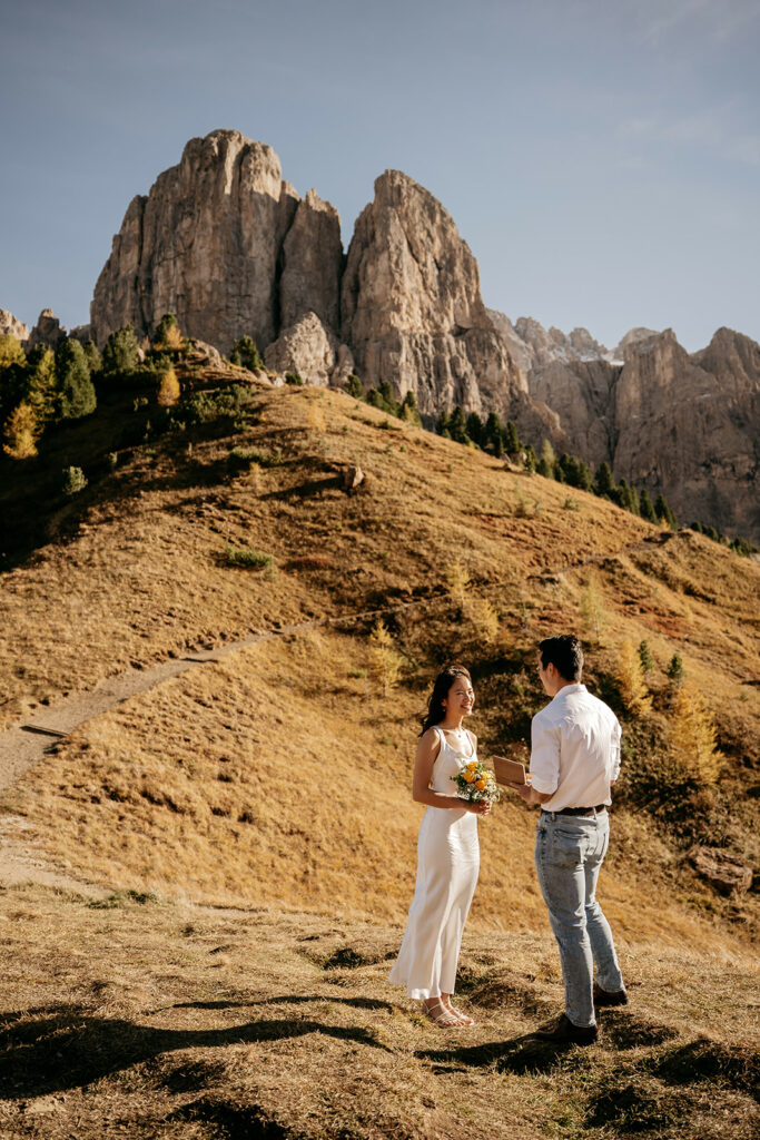 Couple exchanging vows in mountain landscape.