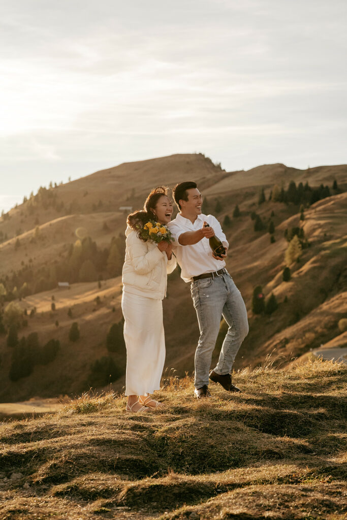 Couple celebrates in scenic mountain setting.