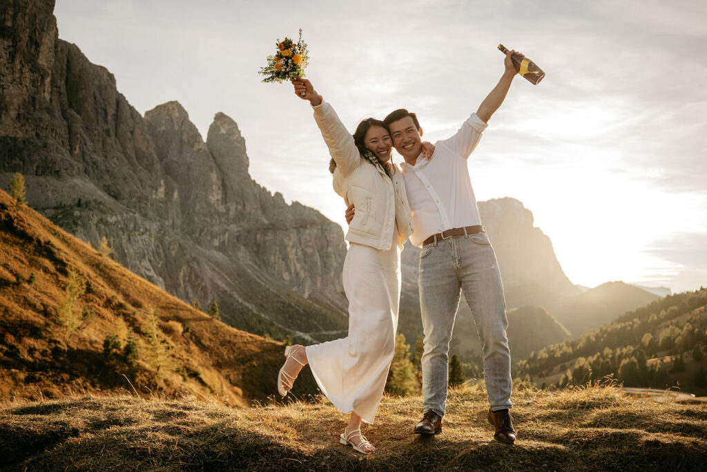 Happy couple celebrating in mountain sunset