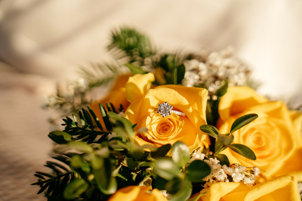 Engagement ring on yellow rose bouquet