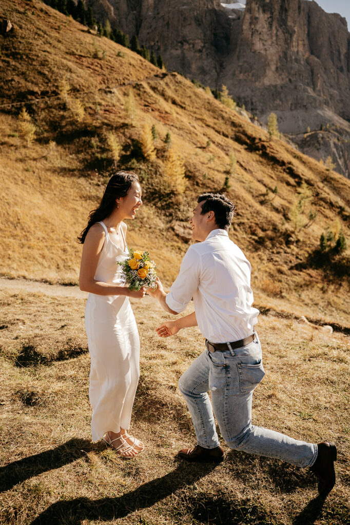 Couple laughing outdoors with flower bouquet