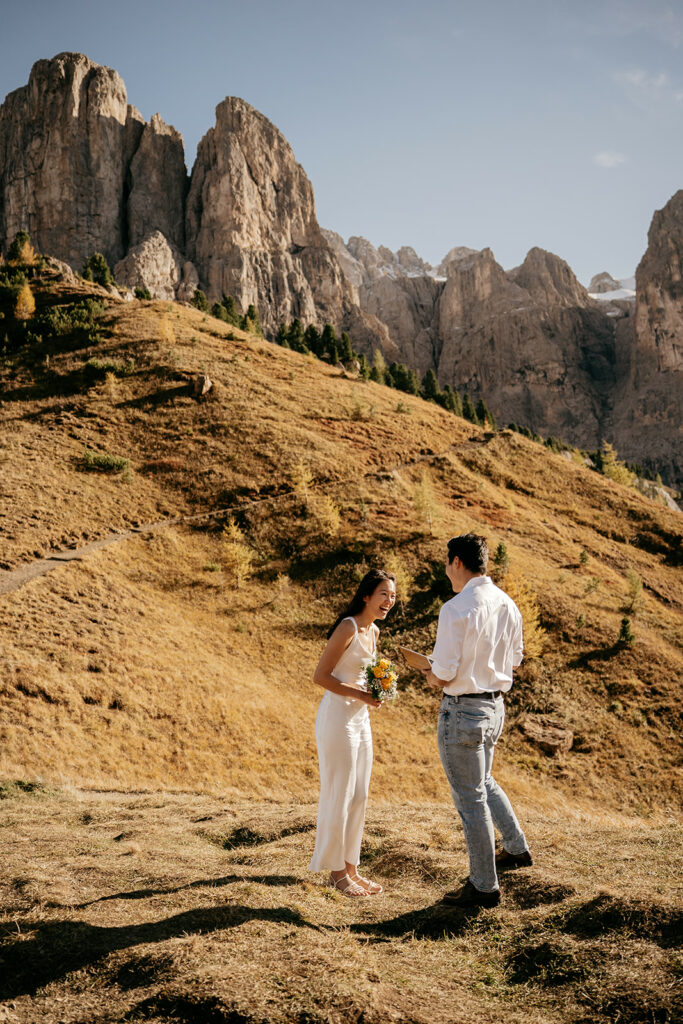 Couple smiling during outdoor ceremony in mountains.