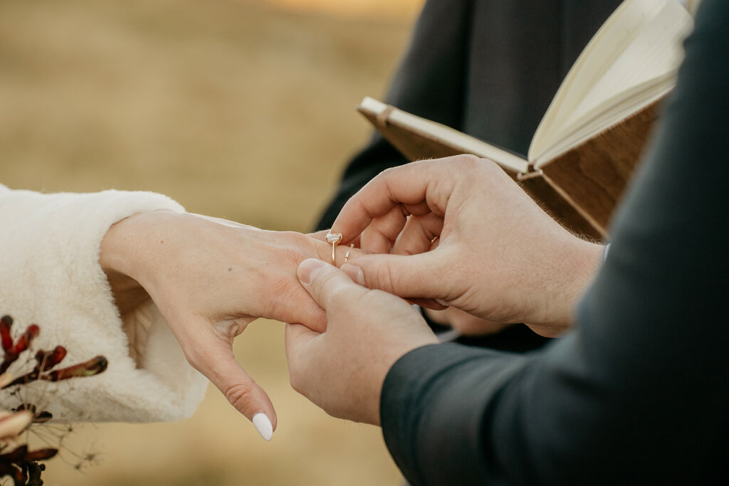 Close-up of ring exchange during wedding ceremony.