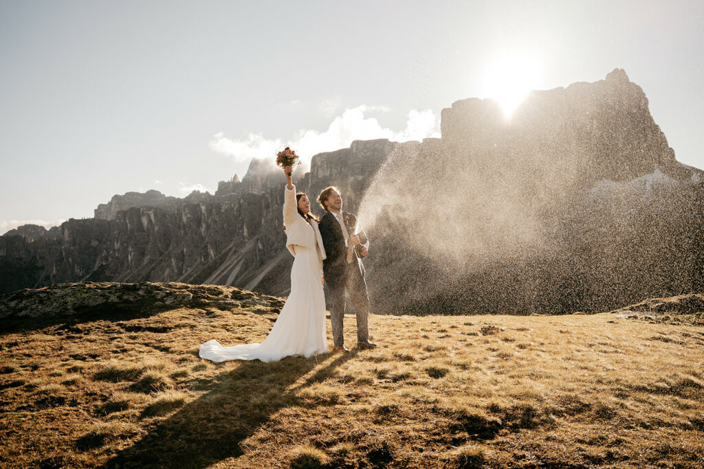 Bride and groom celebrate with champagne in mountains