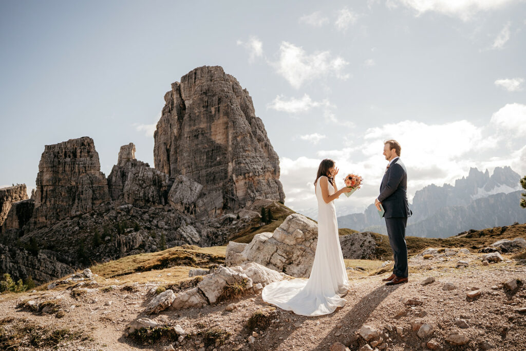 Bride and groom stand in mountain landscape
