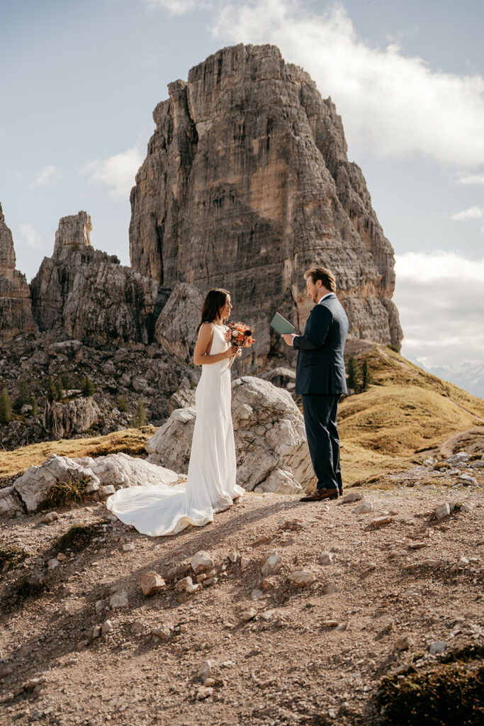 Couple exchanging vows in scenic mountain setting.