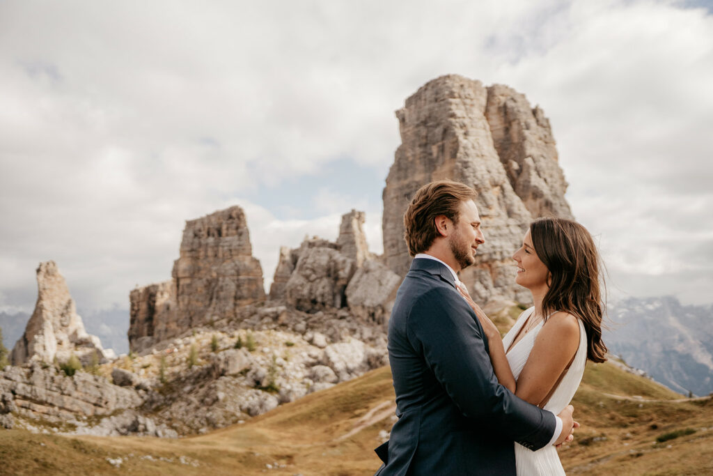 Couple embracing near rocky mountain landscape.