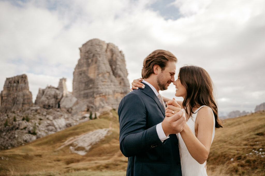 Couple embracing near rocky mountain landscape.