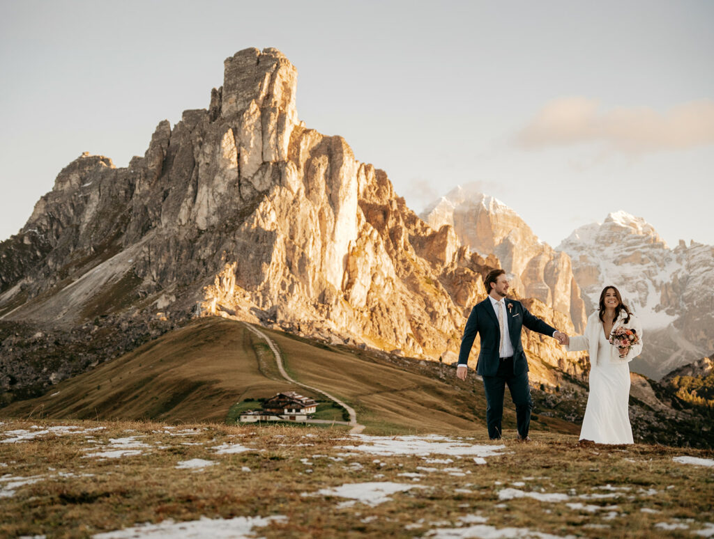 Couple walking outdoors with mountains in background.