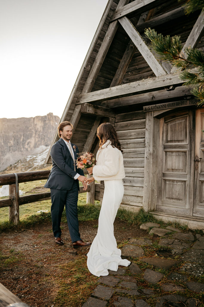 Couple exchanging vows at rustic mountain cabin.