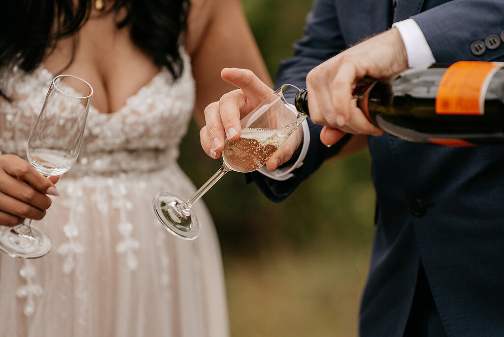 Champagne being poured into a glass at wedding.