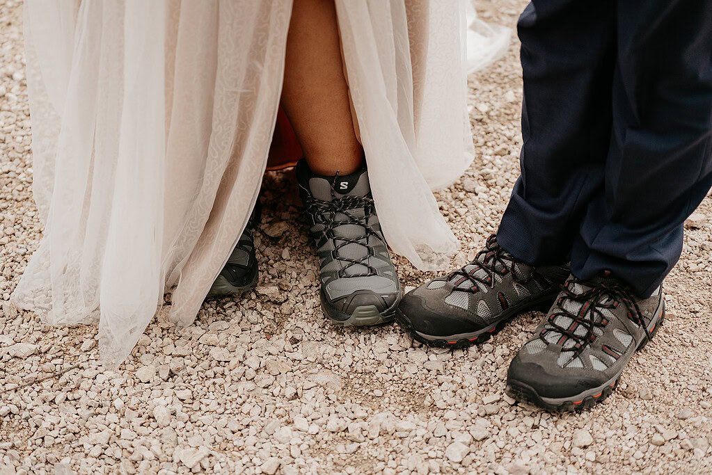 Bride and groom in hiking boots on gravel