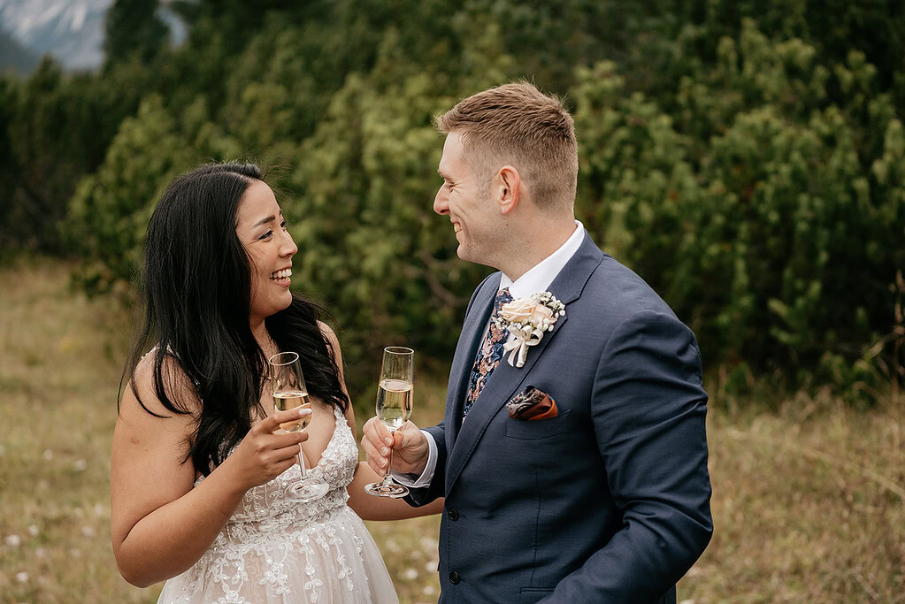Couple toasting with champagne outdoors.