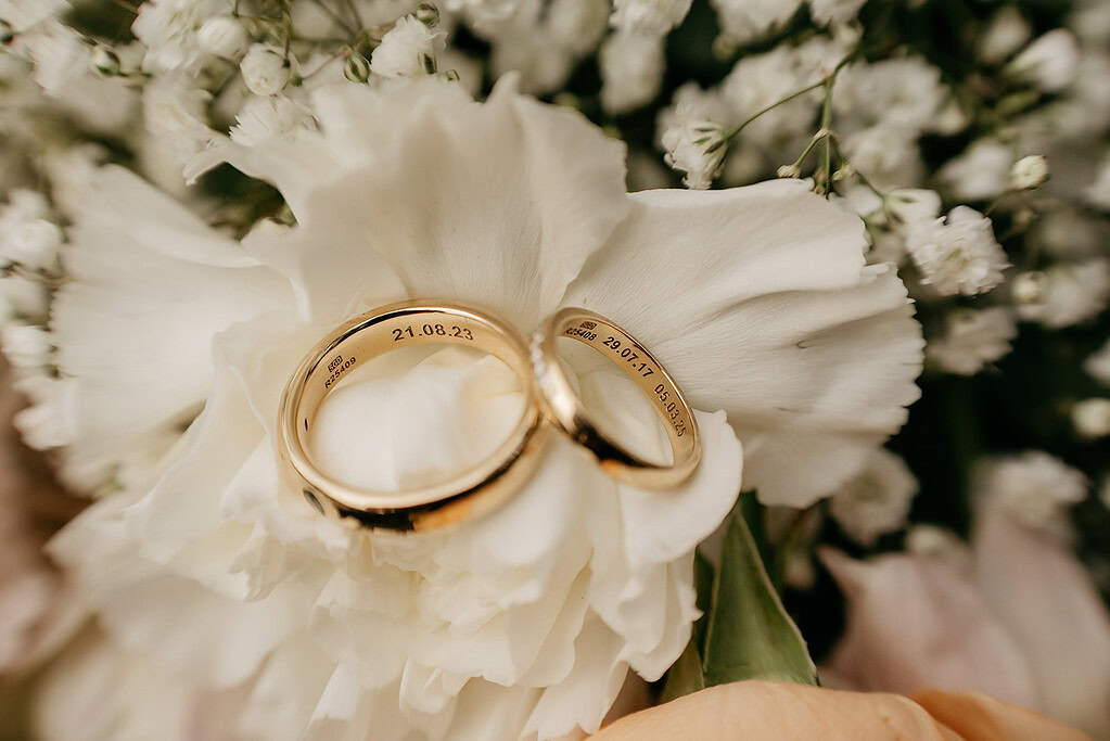 Gold wedding rings on white flowers