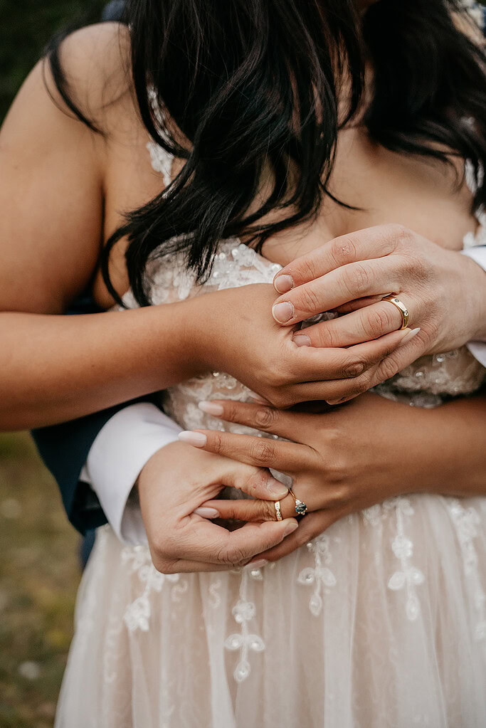 Couple holding hands in wedding attire.