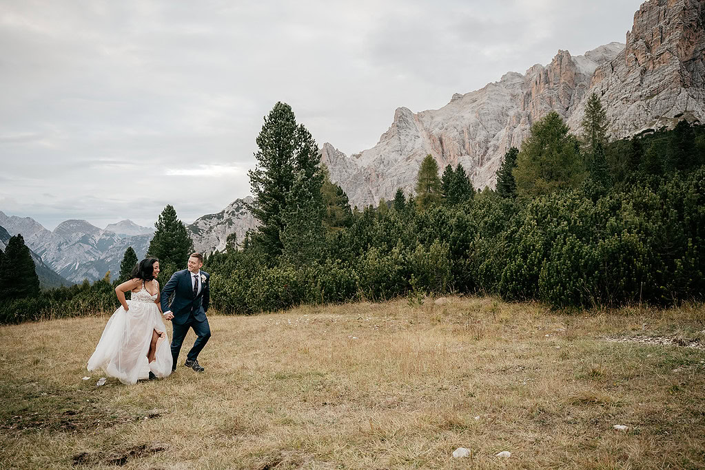 Bride and groom walking in mountain landscape