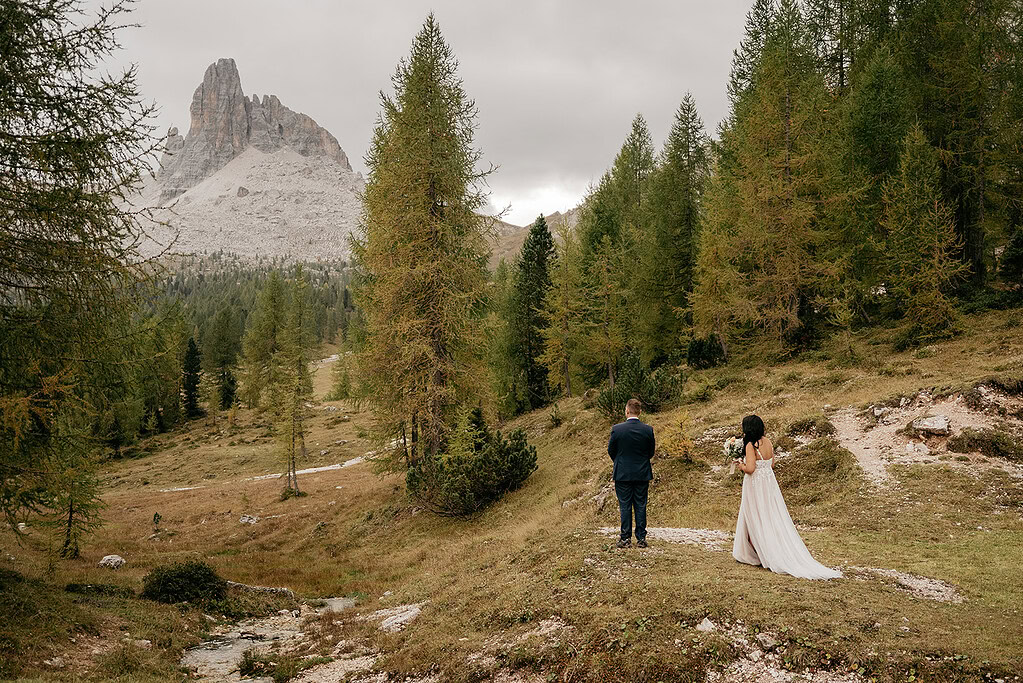 Couple in forest near mountain.