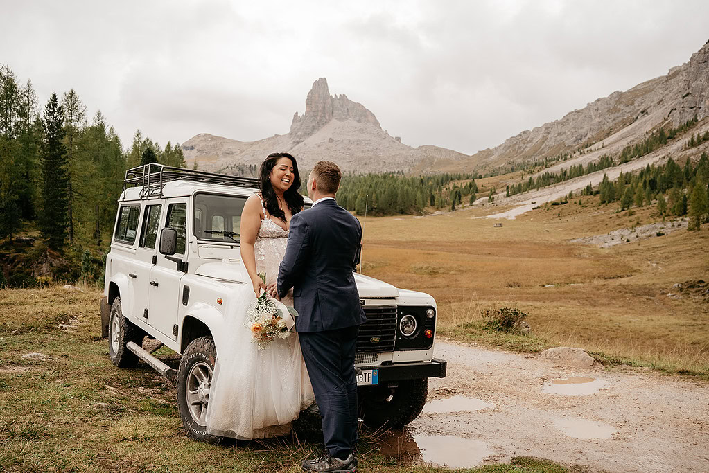 Bride and groom with Land Rover in mountains
