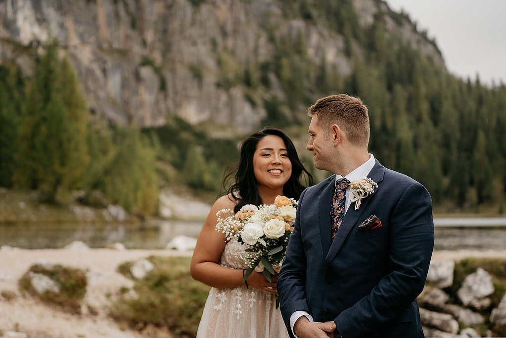 Bride and groom smiling in nature setting.