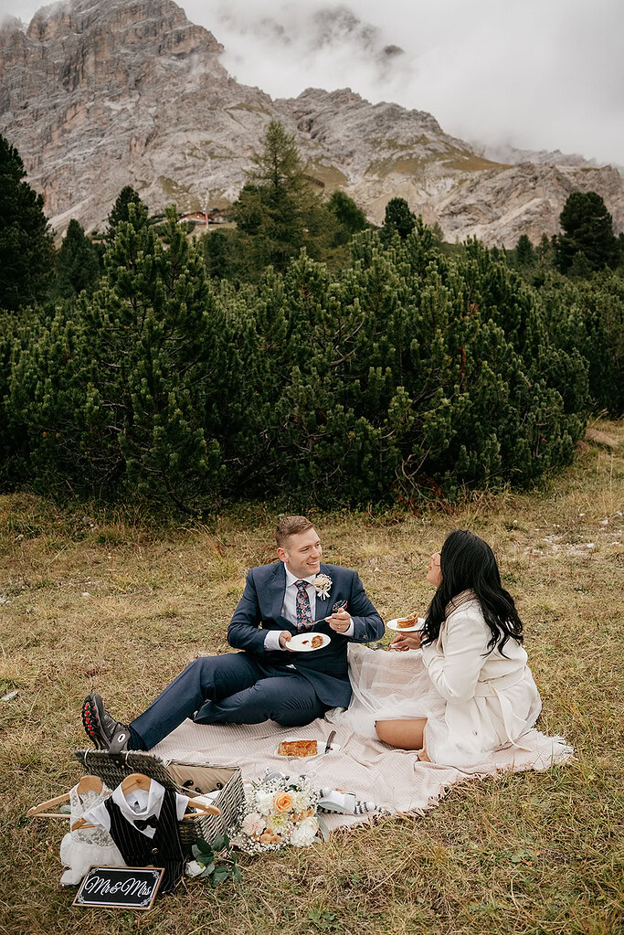 Couple enjoying a picnic in mountain setting.