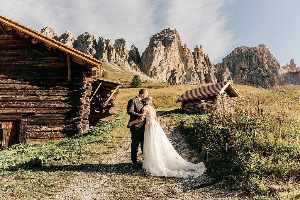 Wedding couple kissing near mountain cabins