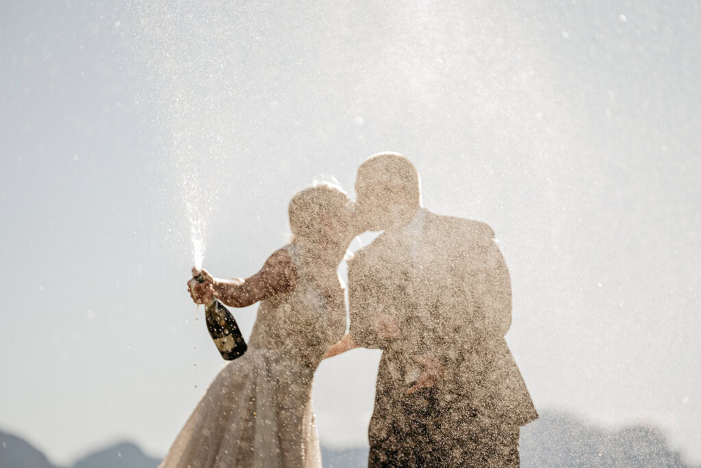 Couple celebrating with champagne spray outdoors