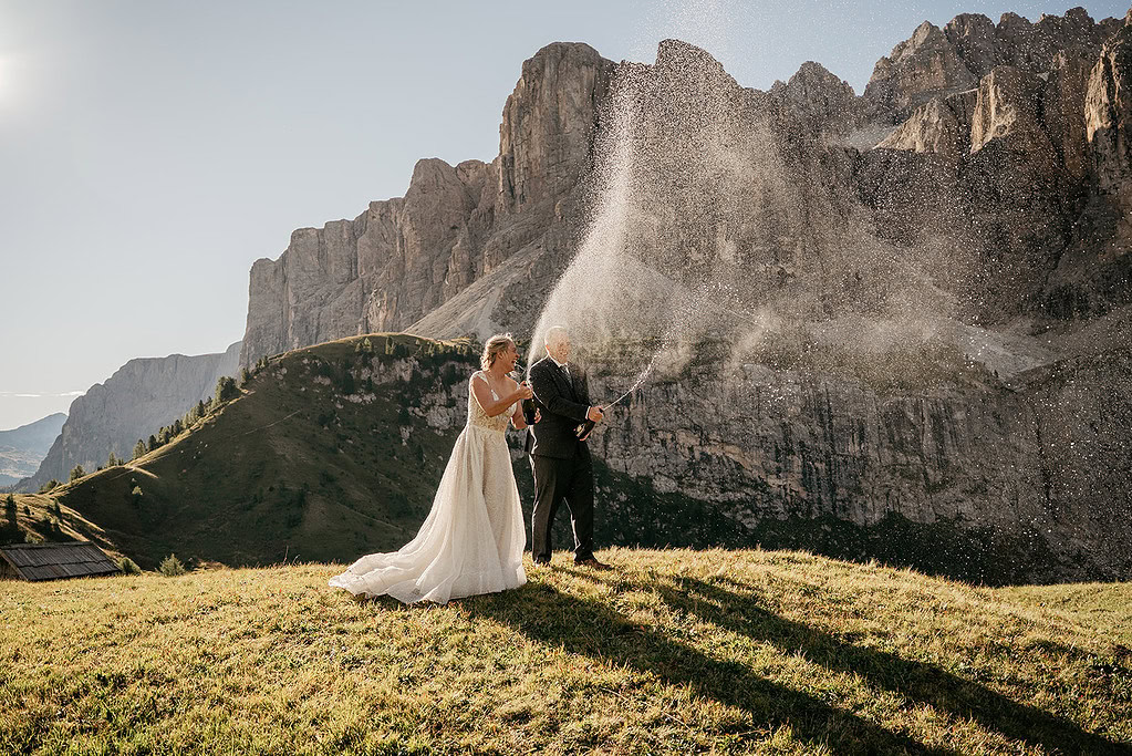 Couple celebrating with champagne in mountains.