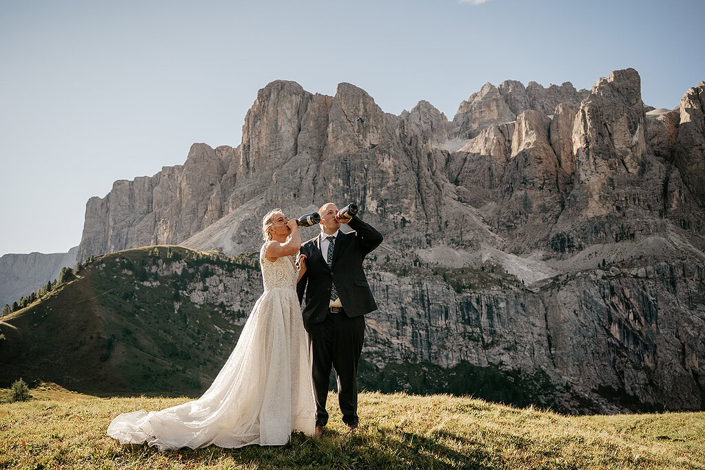 Wedding couple toasting with mountains background.