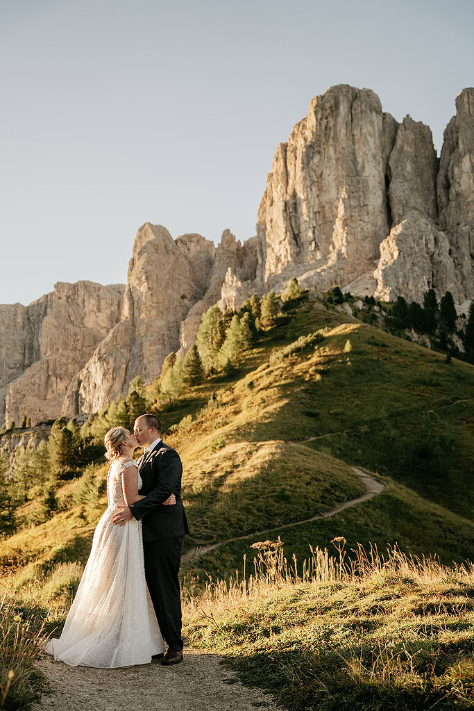 Couple embracing in mountain landscape at sunset.