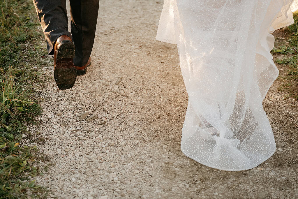Bride and groom walking on gravel path.