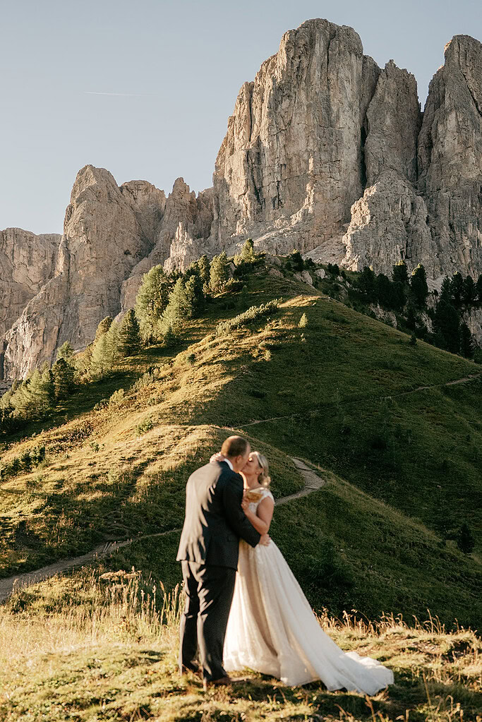 Bride and groom embracing on a mountain hill.