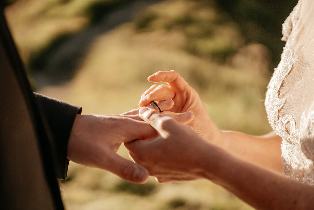 Bride places ring on groom's finger