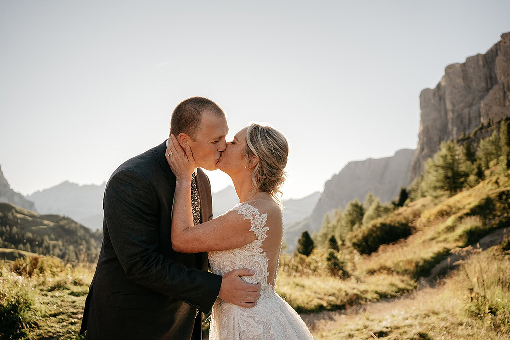 Couple kissing during mountain wedding ceremony